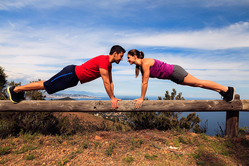 A man and a woman doing push-ups