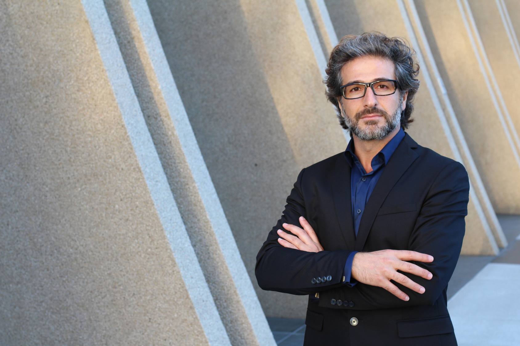 Confident mature businessman posing outside modern office buildi