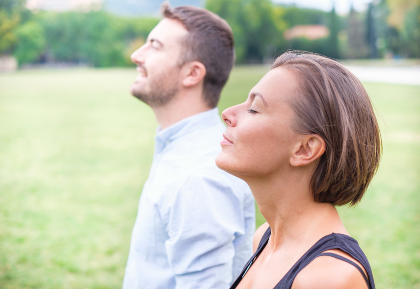 Couple of man and woman breathing deep fresh air together in the