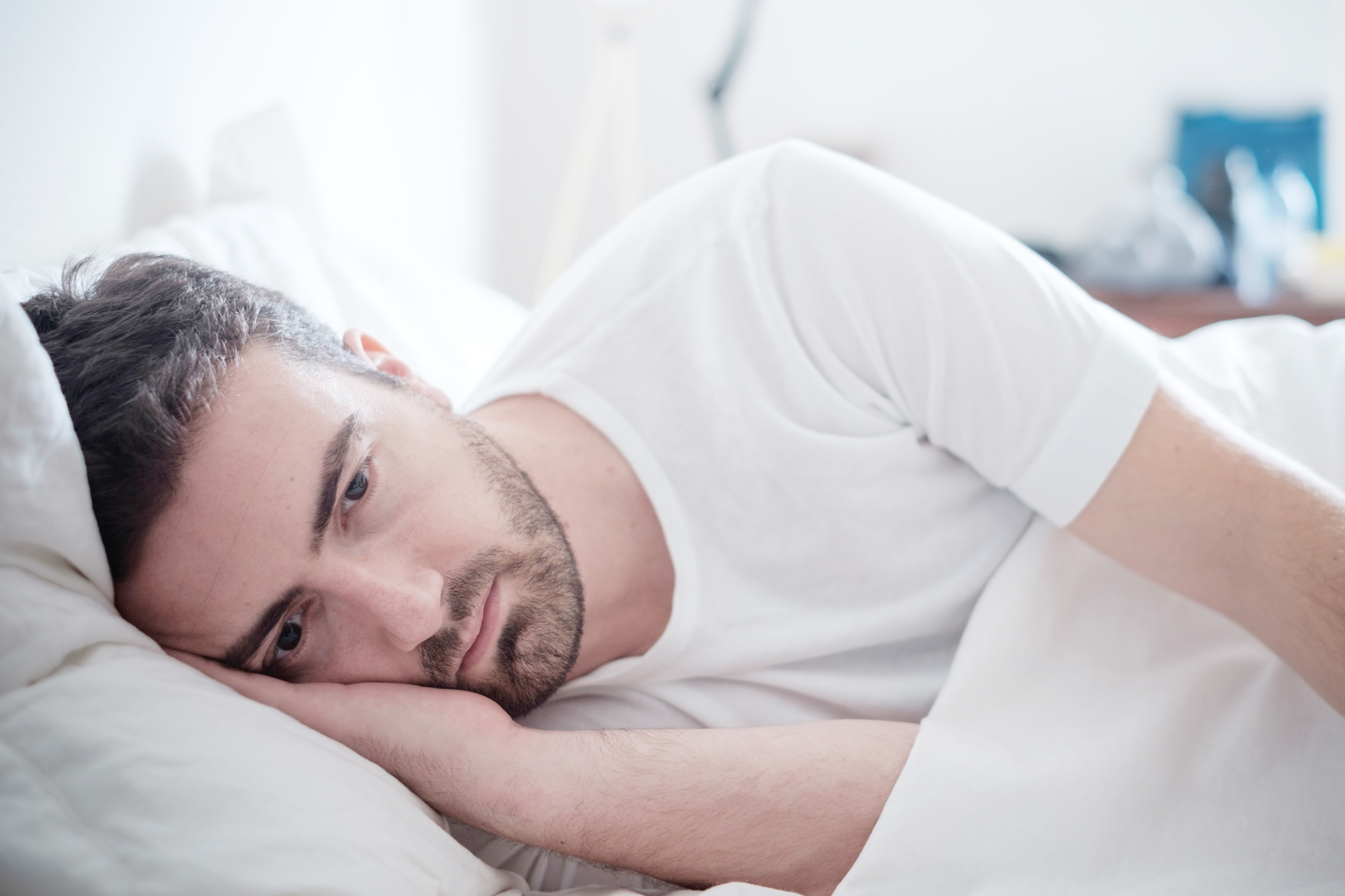 Depressed man lying in his bed and feeling bad